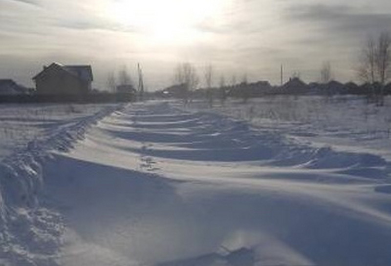 Одну из дорог в Каменске-Уральском заметает снегом — грузовики проехать не могут, а люди сбрасываются на трактор, чтобы выехать из домов