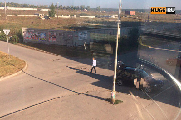 Водитель на BMW остановился на бульваре Комсомольский в Каменске-Уральском и стал… латать ямы. Дорожники приехали через два дня, в дождь