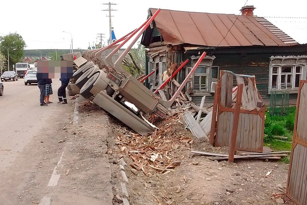 На трассе «Екатеринбург — Каменск-Уральский» - необычное ДТП: фура, груженая бревнами, перевернулась около частного дома, сломав забор